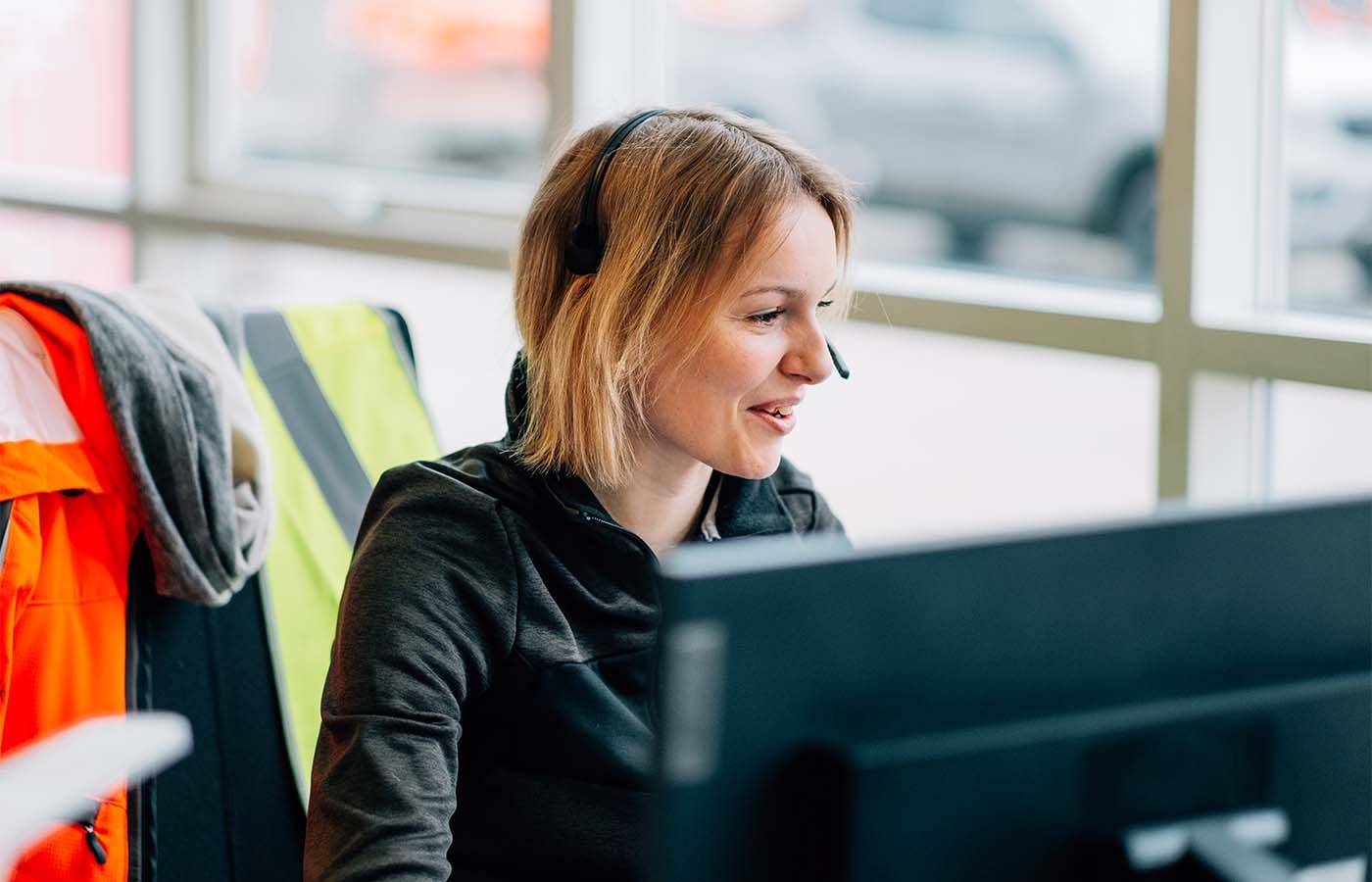 Loxam kundeservicemedarbejder med headset hjælper kunde
